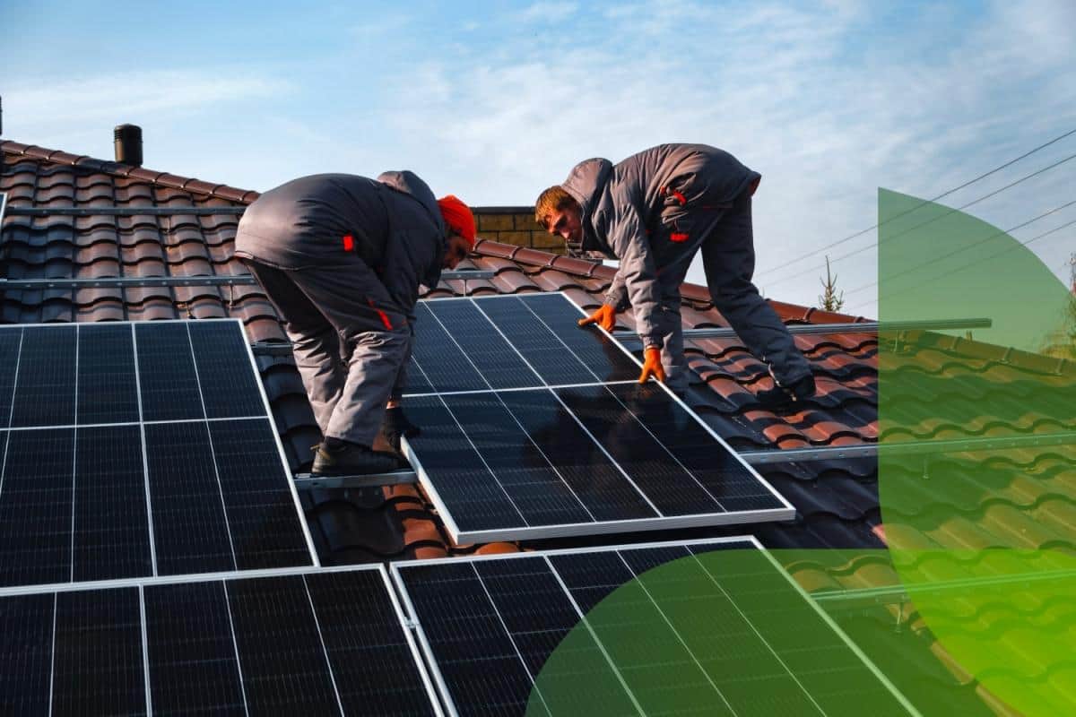Operai che installano dei pannelli fotovoltaici sul tetto di una casa.