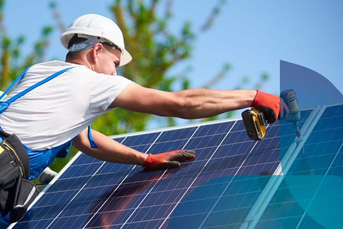 Un tecnico che sta installando un impianto fotovoltaico sul tetto di una casa.