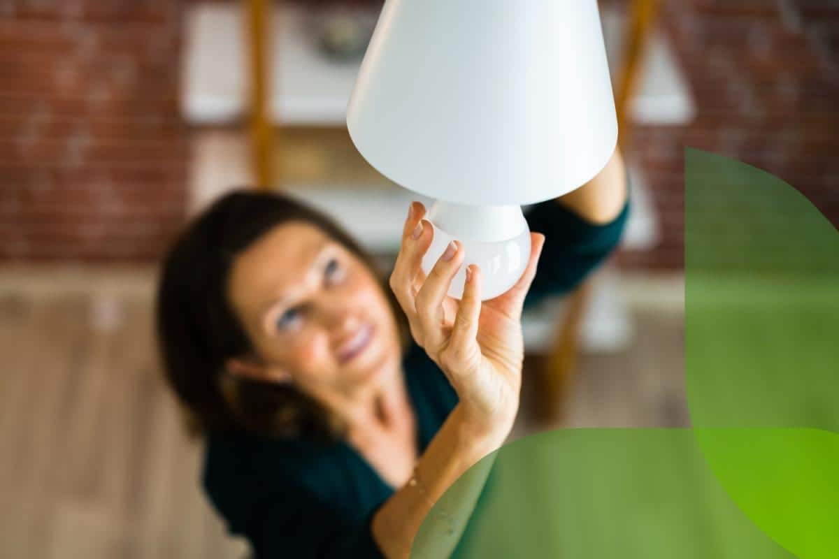 Una donna sostituisce una lampadina in casa